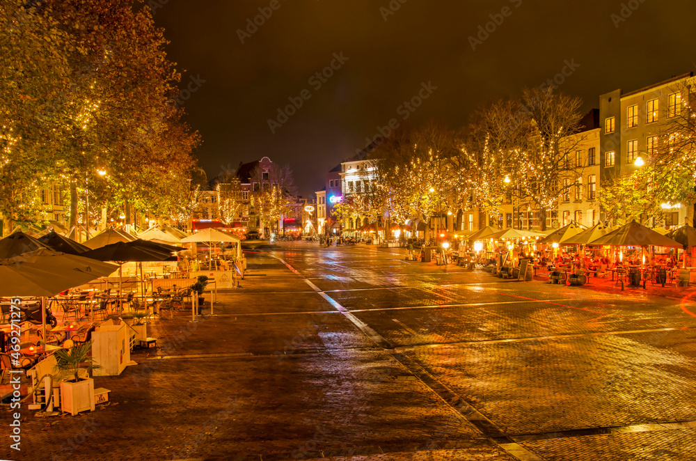 Deventer, The Netherlands, November 13, 2021: after dark view along central Brink square, lined with historic buildings and outdoor cafes