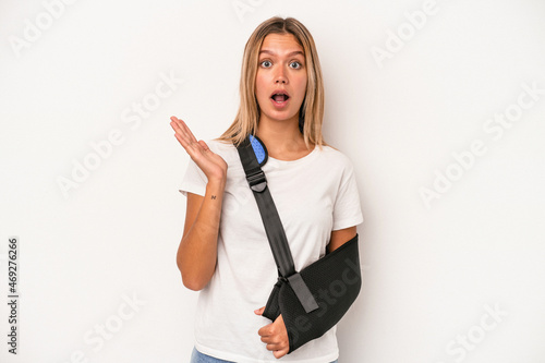 Young caucasian woman with broken hand isolated on white background surprised and shocked.