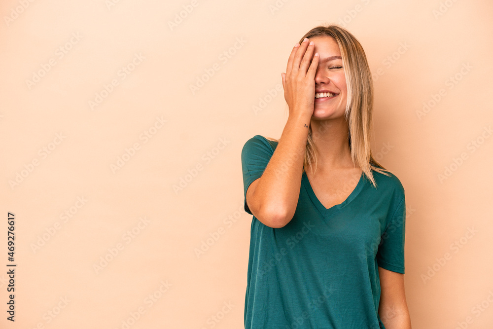 Young caucasian woman isolated on beige background laughing happy, carefree, natural emotion. Young caucasian woman isolated on beige background laughing happy, carefree, natural emotion.