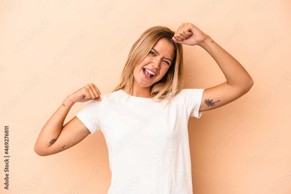 Young caucasian woman isolated on beige background celebrating a special day, jumps and raise arms with energy.