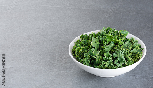 Bowl with kale leaves on gray background. With clipping path.