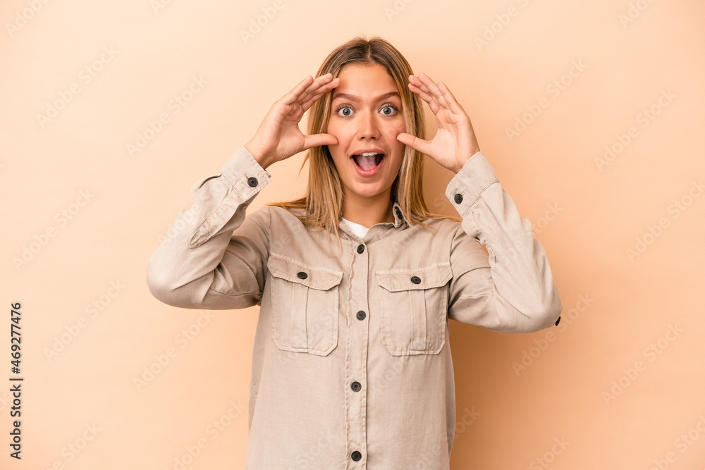 Young caucasian woman isolated on beige background receiving a pleasant surprise, excited and raising hands. Young caucasian woman isolated on beige background receiving a pleasant surprise, excited and raising hands.