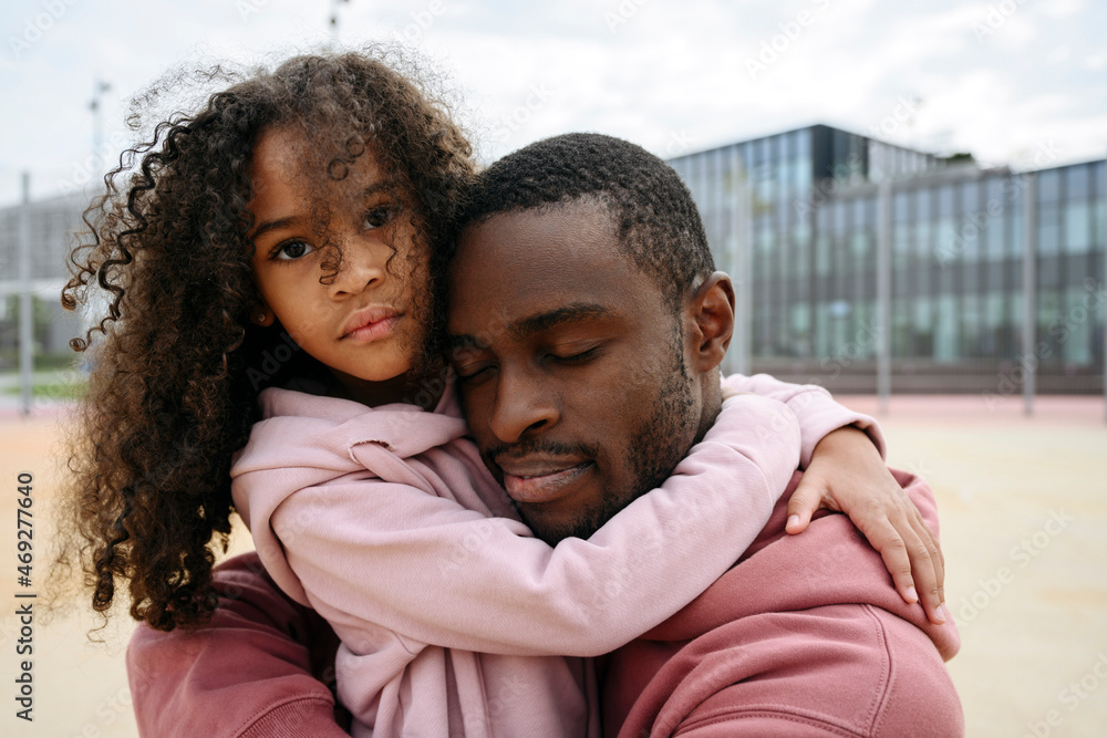Daughter embracing father at sports field Daughter embracing father at sports field