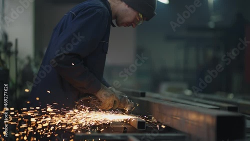 Man works circular saw. Sparks fly from hot metal. Man hard worked over the steel. Slow motion. Sparks from working with steel. photo