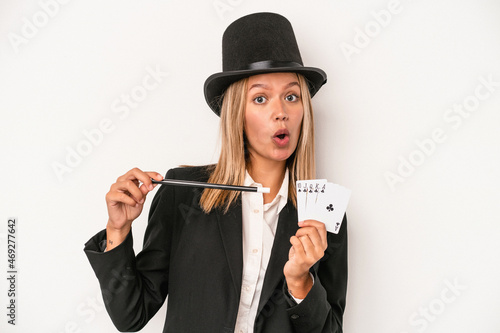 Young caucasian wizard woman holding wand and magic cards isolated on white background photo