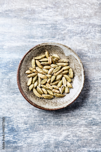  Green Cardamom Seeds on wooden background. Top view. Close up. Copy space.