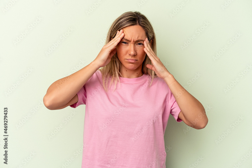 Young caucasian woman isolated on green background touching temples and having headache. Young caucasian woman isolated on green background touching temples and having headache.