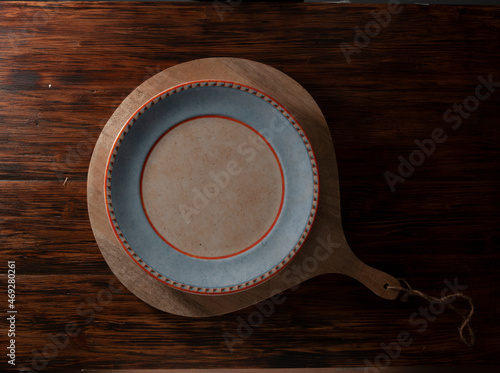 Mesa de madera con tabla y plato, vista cenital. Wooden table with table and plate, overhead view. photo