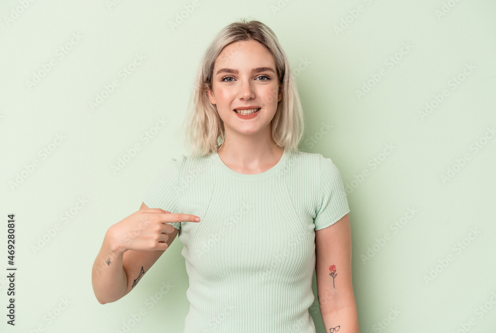 Young caucasian woman isolated on green background person pointing by hand to a shirt copy space, proud and confident Young caucasian woman isolated on green background person pointing by hand to a shirt copy space, proud and confident