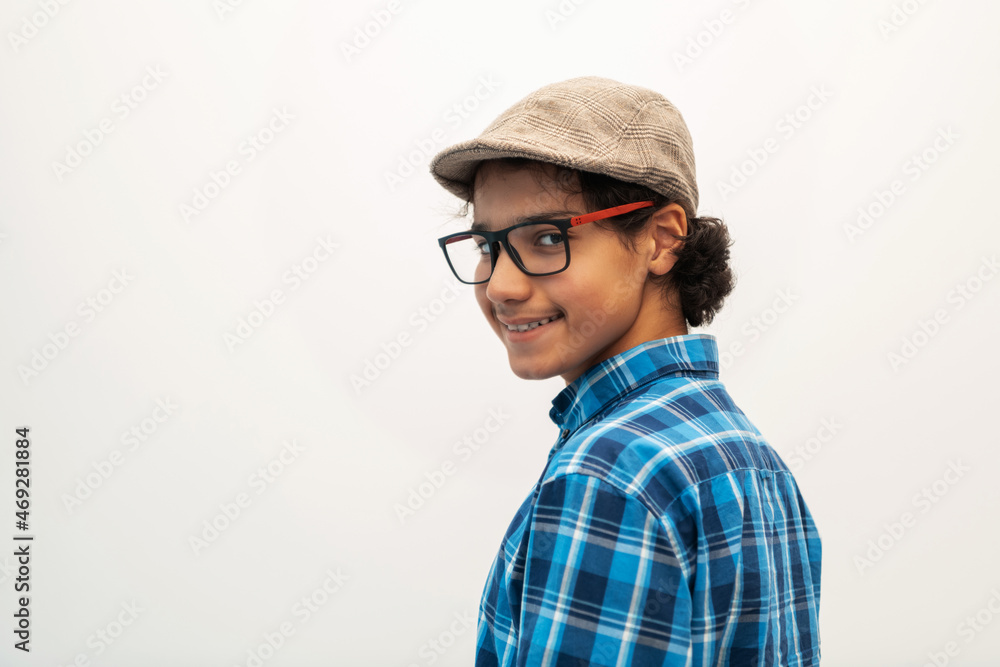 portrait of smart looking arab teenager with glasses wearing a hat in casual school look isolated on white copy space portrait of smart looking arab teenager with glasses wearing a hat in casual school look isolated on white copy space