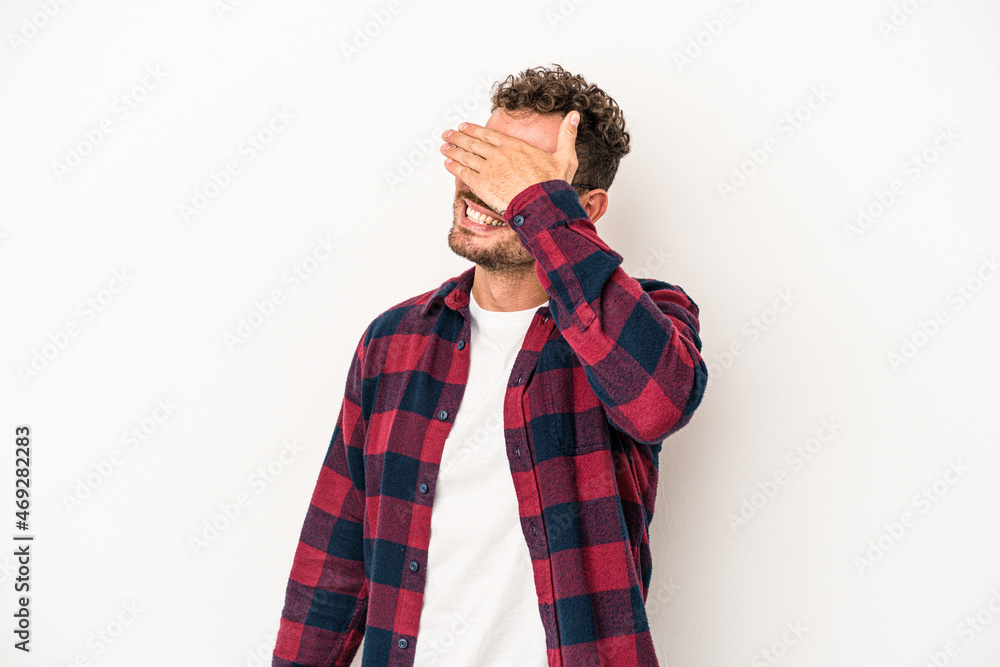 Young caucasian man isolated on white background covers eyes with hands, smiles broadly waiting for a surprise. Young caucasian man isolated on white background covers eyes with hands, smiles broadly waiting for a surprise.