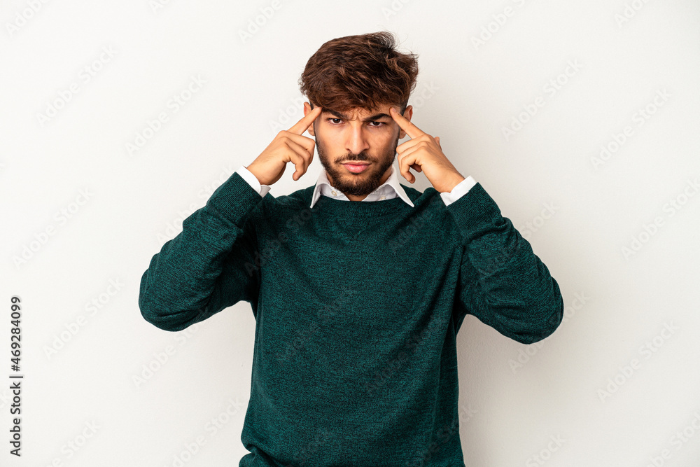 Young mixed race man isolated on grey background focused on a task, keeping forefingers pointing head. Young mixed race man isolated on grey background focused on a task, keeping forefingers pointing head.