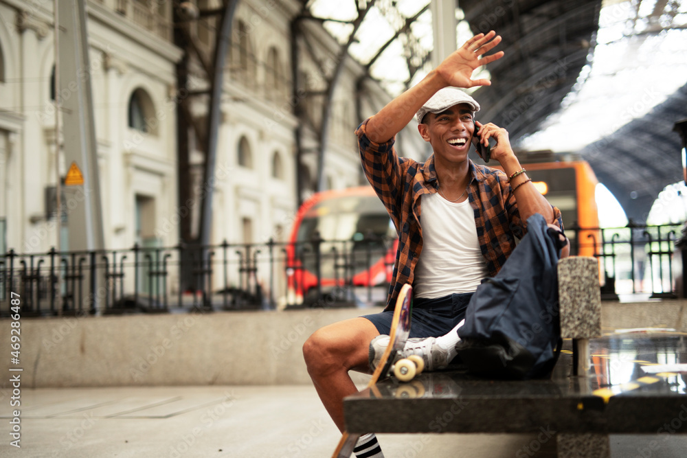 Obraz premium Happy young man waiting for the train. African man waiting in a subway. Man using a phone