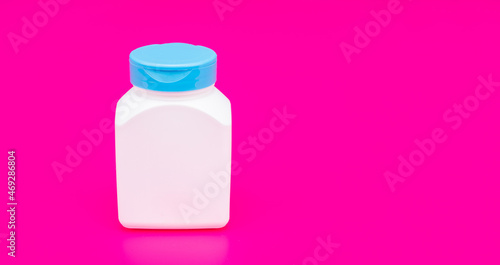 presenting vitamin product. white unbranded pill jar. multivitamin bottle on pink background.