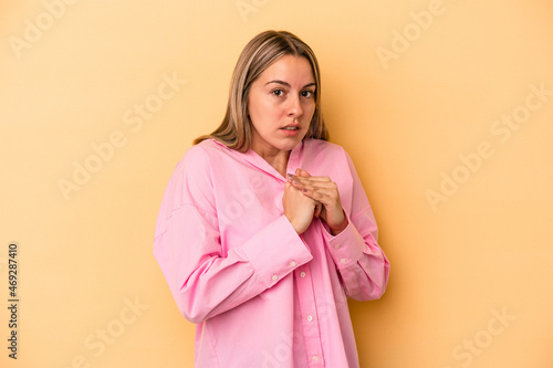 Young caucasian woman isolated on yellow background scared and afraid.