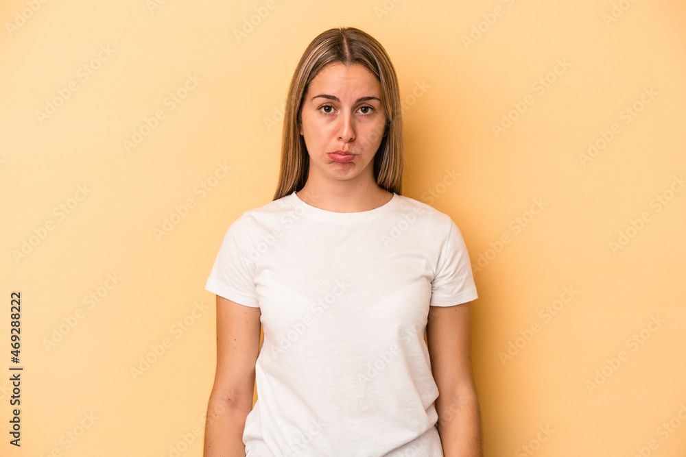 Young caucasian woman isolated on yellow background sad, serious face, feeling miserable and displeased. Young caucasian woman isolated on yellow background sad, serious face, feeling miserable and displeased.