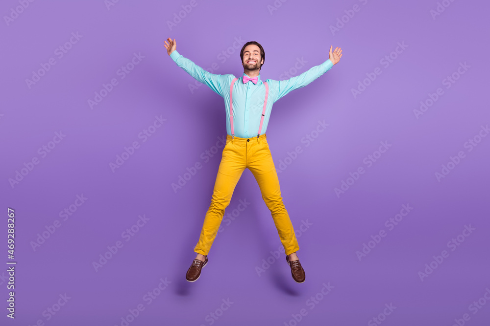 Full length photo of hipster millennial guy jump wear tie suspenders shirt pants sneakers isolated on purple background Full length photo of hipster millennial guy jump wear tie suspenders shirt pants sneakers isolated on purple background