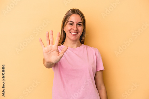 Wallpaper Mural Young caucasian woman isolated on yellow background smiling cheerful showing number five with fingers. Torontodigital.ca