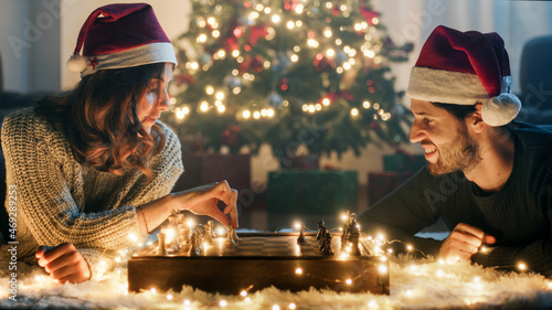 Coppia di ragazzo e ragazza giocano a scacchi nel periodo di Natale photo