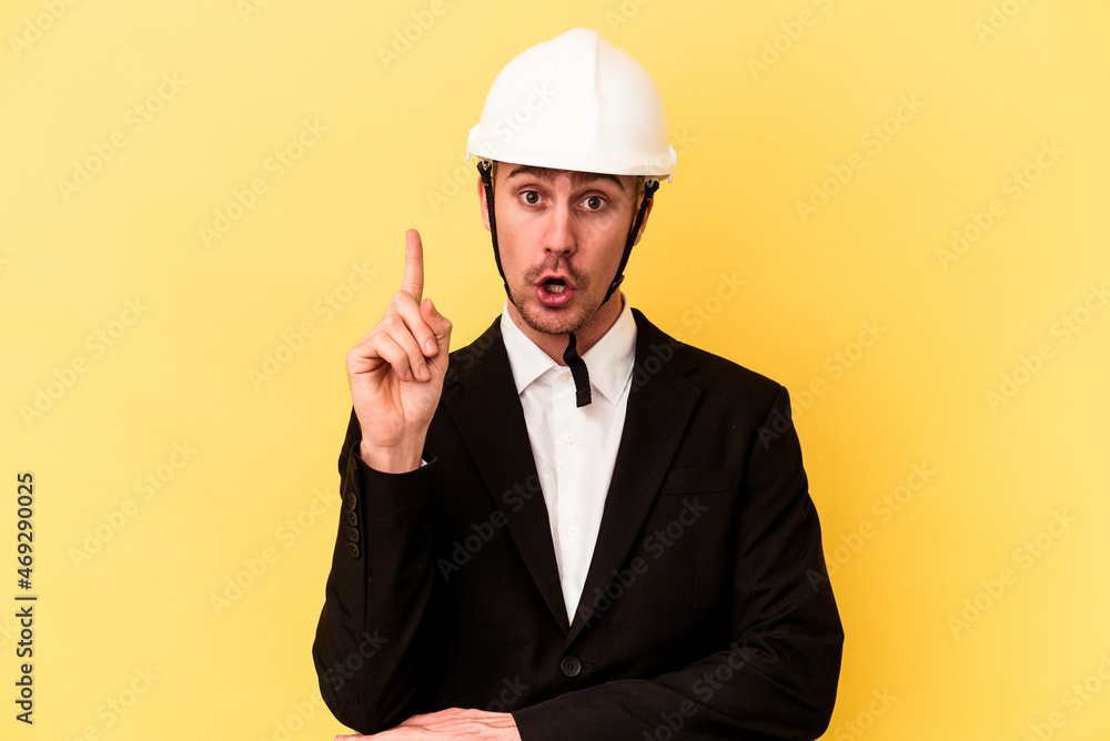 Young architect caucasian man isolated on yellow background having some great idea, concept of creativity.