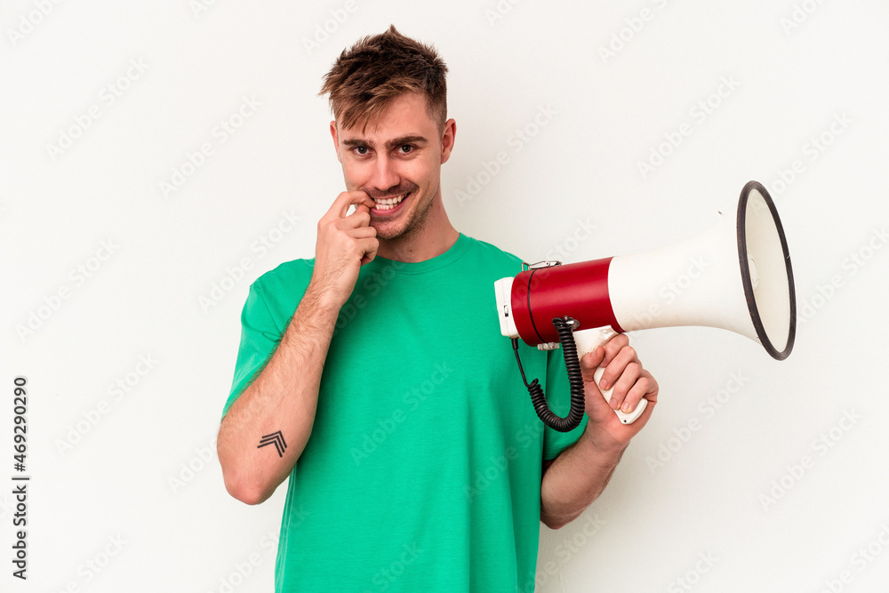 Young caucasian man holding megaphone isolated on white background relaxed thinking about something looking at a copy space. Young caucasian man holding megaphone isolated on white background relaxed thinking about something looking at a copy space.