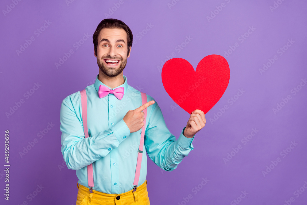 Photo of cool young brunet guy index heart wear tie suspenders blue shirt isolated on purple background Photo of cool young brunet guy index heart wear tie suspenders blue shirt isolated on purple background