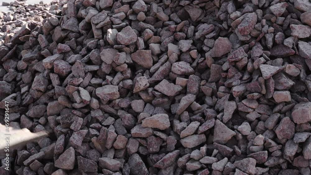 Close-up shot of a man shoveling a shovel full of construction crushed stone Close-up shot of a man shoveling a shovel full of construction crushed stone