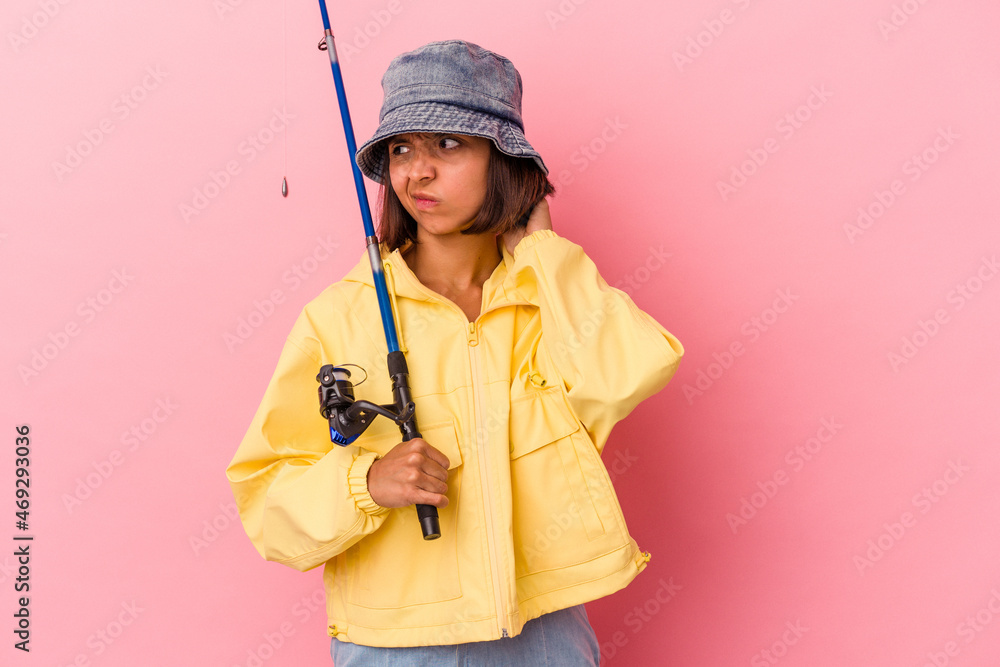 Young mixed race woman practicing fishing isolated on pink background touching back of head, thinking and making a choice. Young mixed race woman practicing fishing isolated on pink background touching back of head, thinking and making a choice.