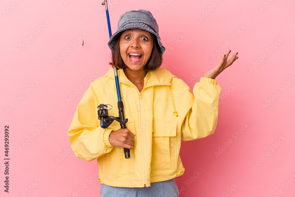 Young mixed race woman practicing fishing isolated on pink background receiving a pleasant surprise, excited and raising hands. Young mixed race woman practicing fishing isolated on pink background receiving a pleasant surprise, excited and raising hands.