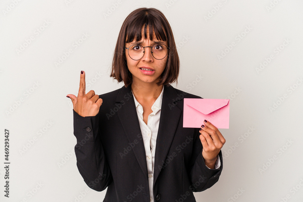 Young mixed race business woman holding a letter isolated on white background showing a disappointment gesture with forefinger. Young mixed race business woman holding a letter isolated on white background showing a disappointment gesture with forefinger.