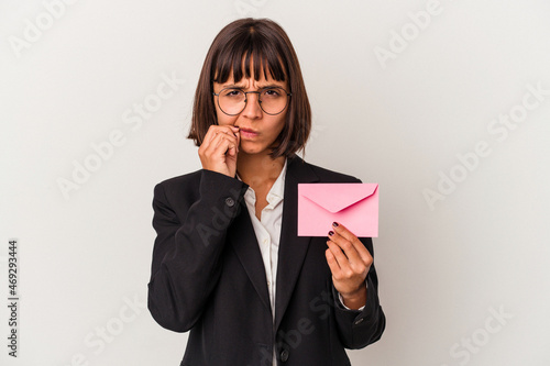 Young mixed race business woman holding a letter isolated on white background with fingers on lips keeping a secret. photo