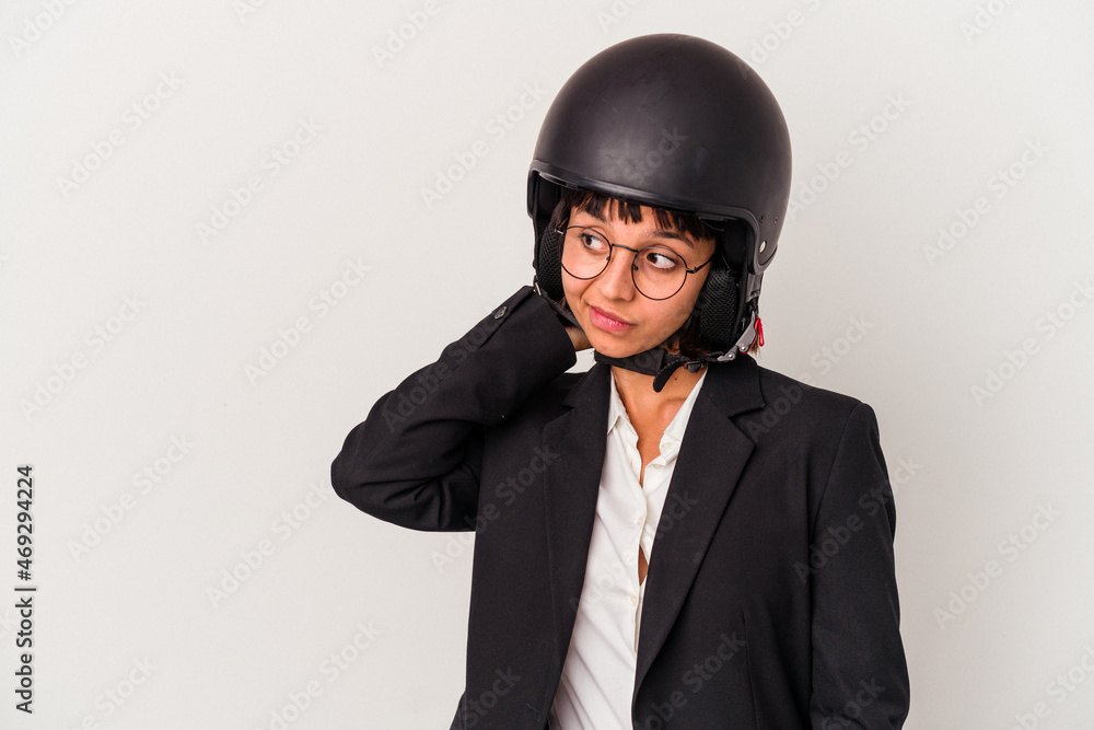 Young mixed race business woman wearing a motorbike helmet isolated touching back of head, thinking and making a choice. Young mixed race business woman wearing a motorbike helmet isolated touching back of head, thinking and making a choice.