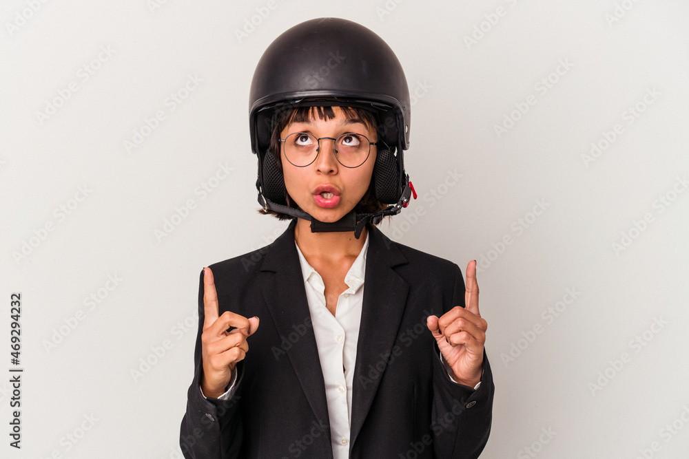 Young mixed race business woman wearing a motorbike helmet isolated pointing upside with opened mouth. Young mixed race business woman wearing a motorbike helmet isolated pointing upside with opened mouth.