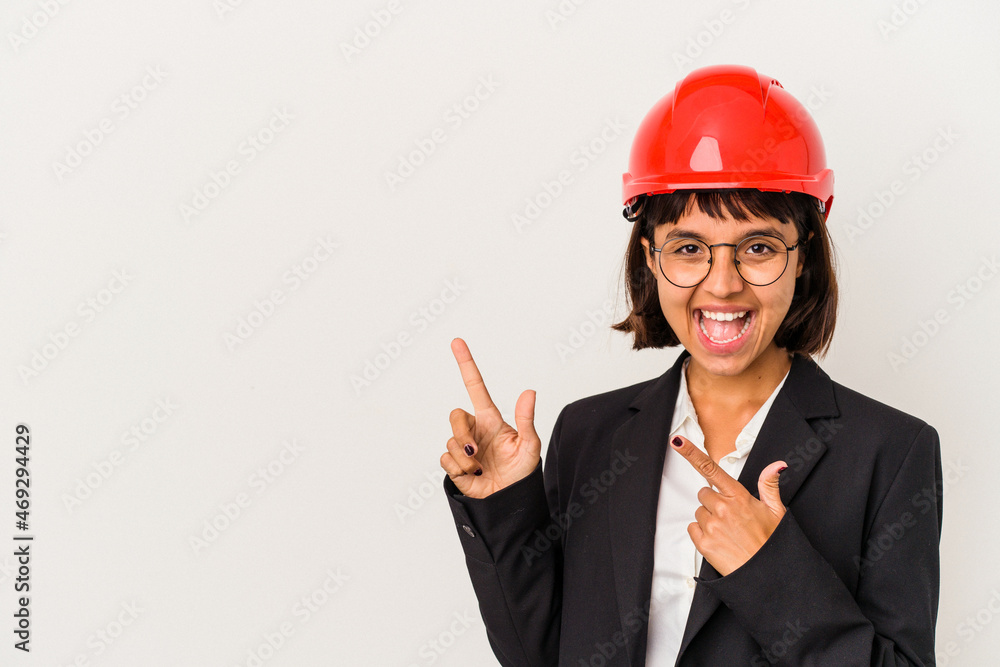 Young architect woman with red helmet isolated on white background pointing with forefingers to a copy space, expressing excitement and desire. Young architect woman with red helmet isolated on white background pointing with forefingers to a copy space, expressing excitement and desire.