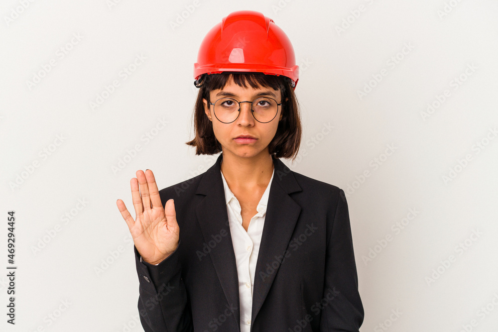 Young architect woman with red helmet isolated on white background standing with outstretched hand showing stop sign, preventing you. Young architect woman with red helmet isolated on white background standing with outstretched hand showing stop sign, preventing you.