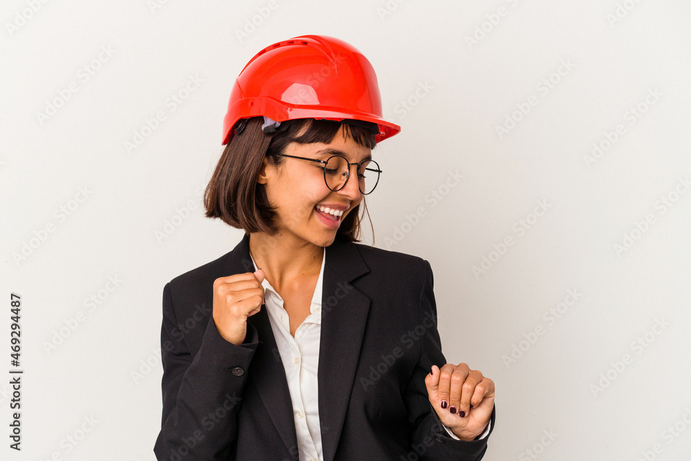 Young architect woman with red helmet isolated on white background dancing and having fun.