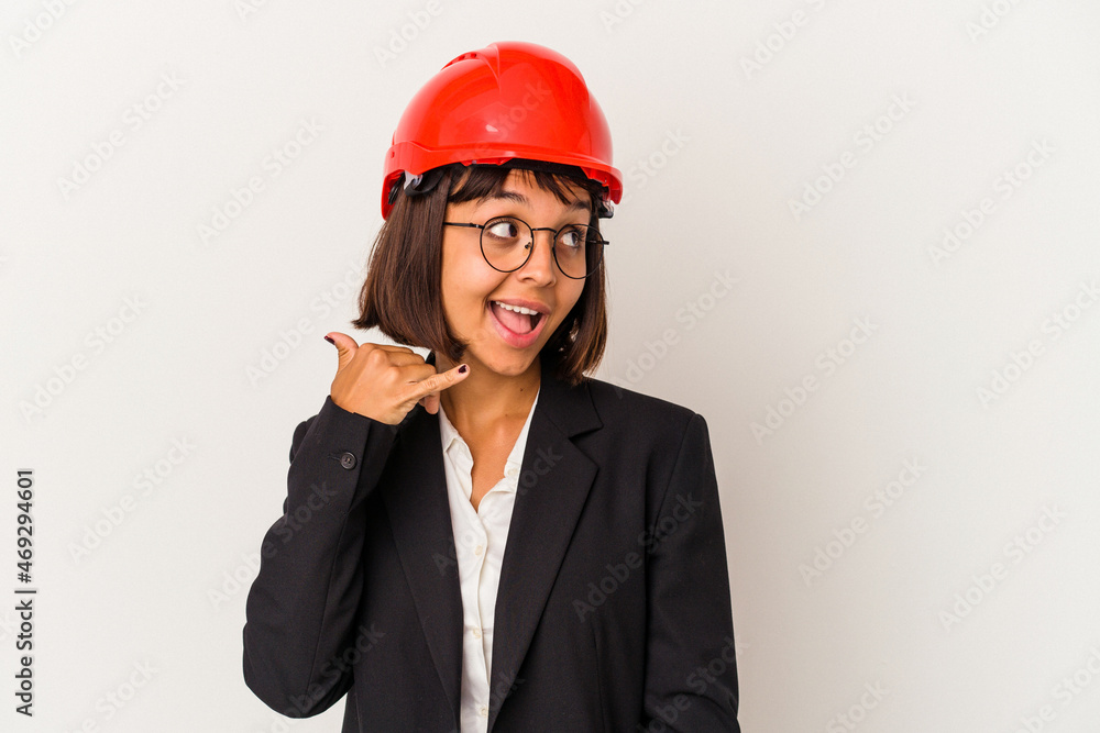 Young architect woman with red helmet isolated on white background showing a mobile phone call gesture with fingers. Young architect woman with red helmet isolated on white background showing a mobile phone call gesture with fingers.