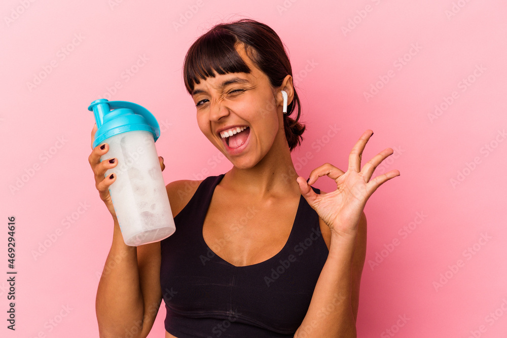 Young mixed race woman drinking a protein shake isolated on pink background Young mixed race woman drinking a protein shake isolated on pink background