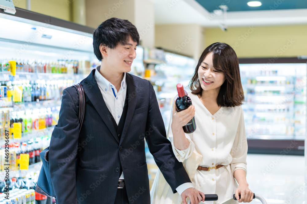 お店でワインを購入する若い夫婦 お店でワインを購入する若い夫婦