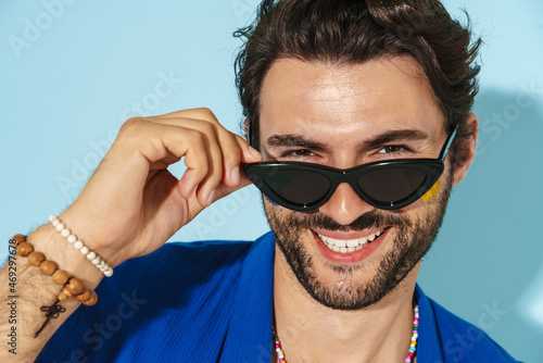 Young man wearing sunglasses laughing and looking at camera © Drobot Dean