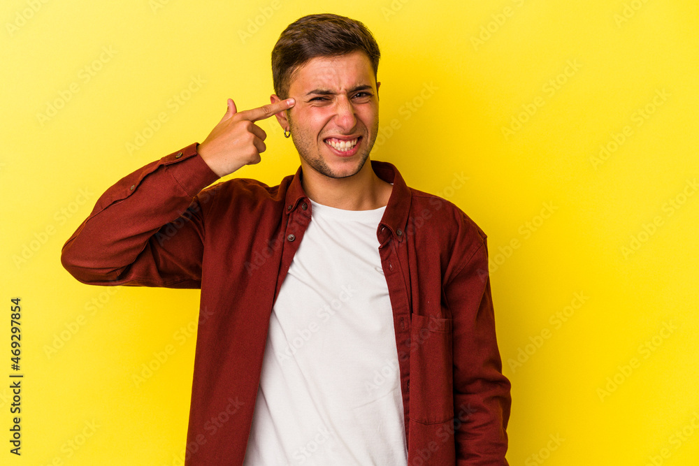 Young caucasian man with tattoos isolated on yellow background covering ears with hands. Young caucasian man with tattoos isolated on yellow background covering ears with hands.