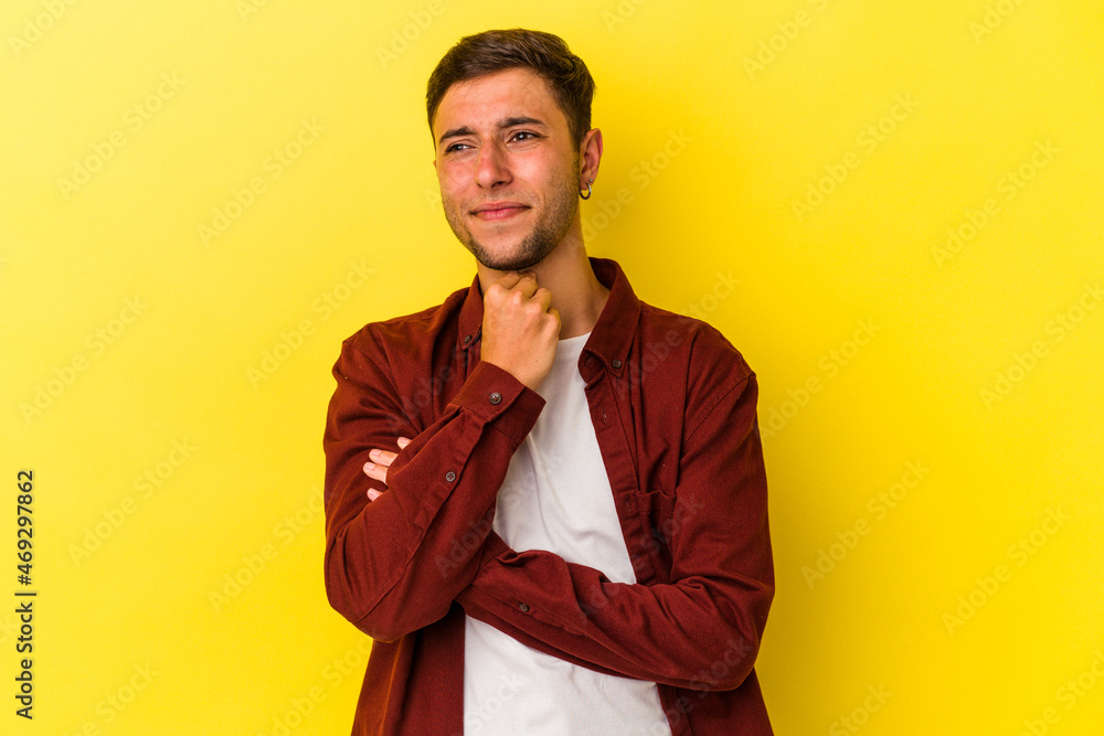 Young caucasian man with tattoos isolated on yellow background suffers pain in throat due a virus or infection. Young caucasian man with tattoos isolated on yellow background suffers pain in throat due a virus or infection.
