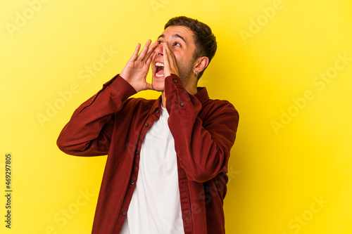 Young caucasian man with tattoos isolated on yellow background shouting excited to front.