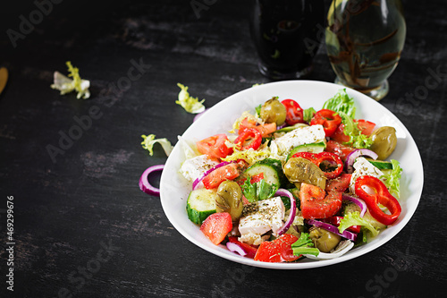 Greek salad of fresh tomato, sweet pepper, cucumber, red onion, feta cheese and green olives. Healthy vegetarian food.