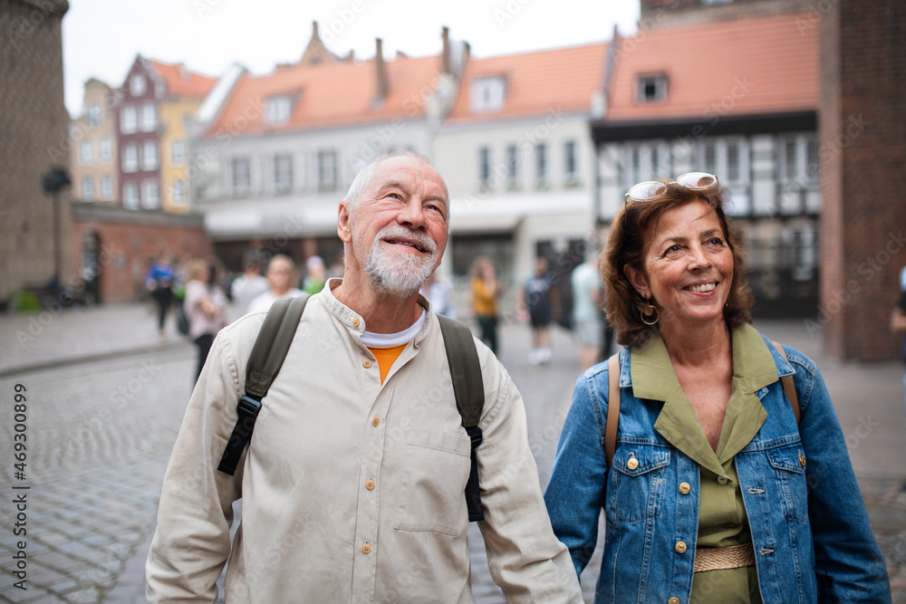 Portrait of happy senior couple tourists outdoors in historic town Portrait of happy senior couple tourists outdoors in historic town