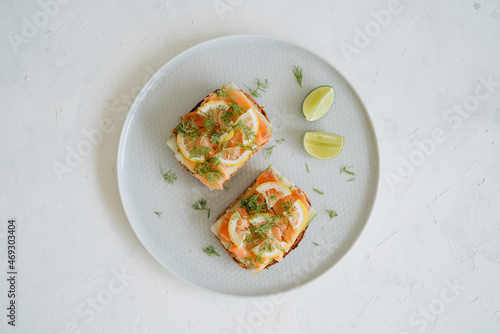Salmon toasts on a plate on white background