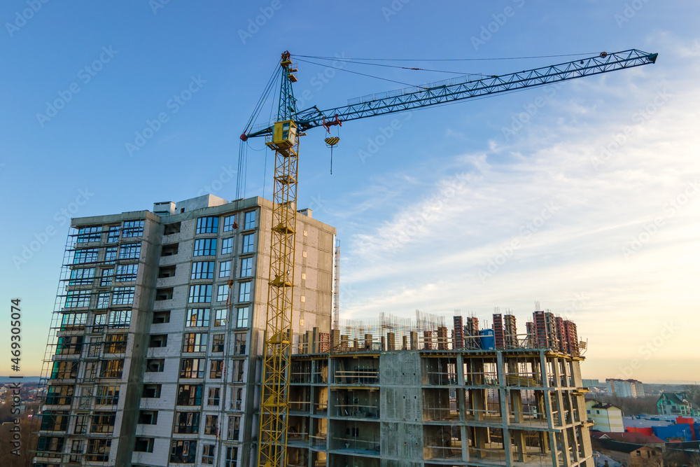 Aerial view of high tower crane and residential apartment buildings under construction. Real estate development Aerial view of high tower crane and residential apartment buildings under construction. Real estate development
