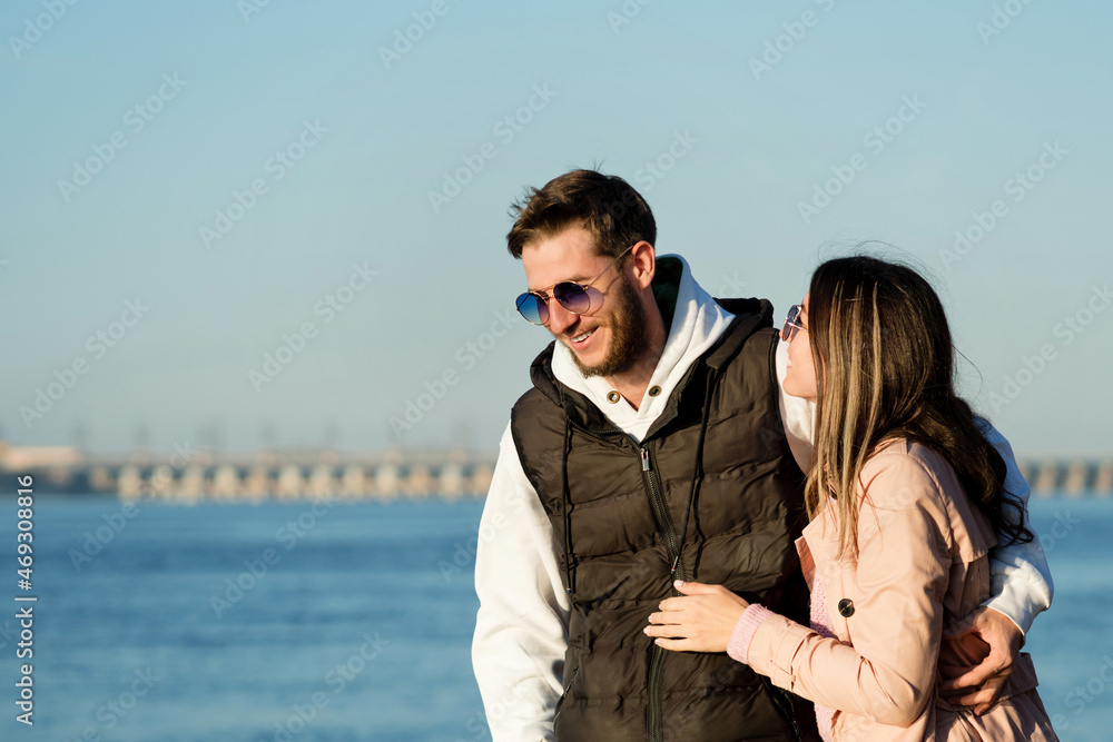Stylish couple walking and hugging by the sea beach. Lovely hipster lovers having fun together outdoors. Concept of youth, love and lifestyle. Stylish couple walking and hugging by the sea beach. Lovely hipster lovers having fun together outdoors. Concept of youth, love and lifestyle.
