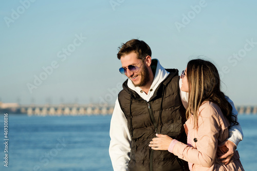 Stylish couple walking and hugging by the sea beach. Lovely hipster lovers having fun together outdoors. Concept of youth, love and lifestyle. © Vagengeim