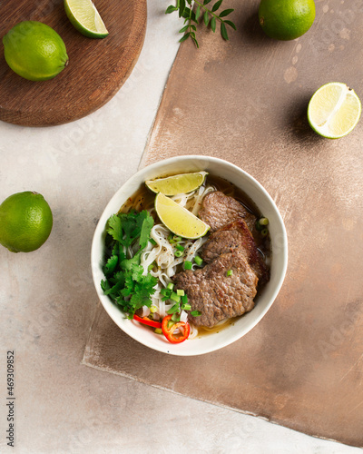 Vietnamese Pho-bo soup. Rice noodles and beef. Serving Asian food. Vietnamese food. Limes